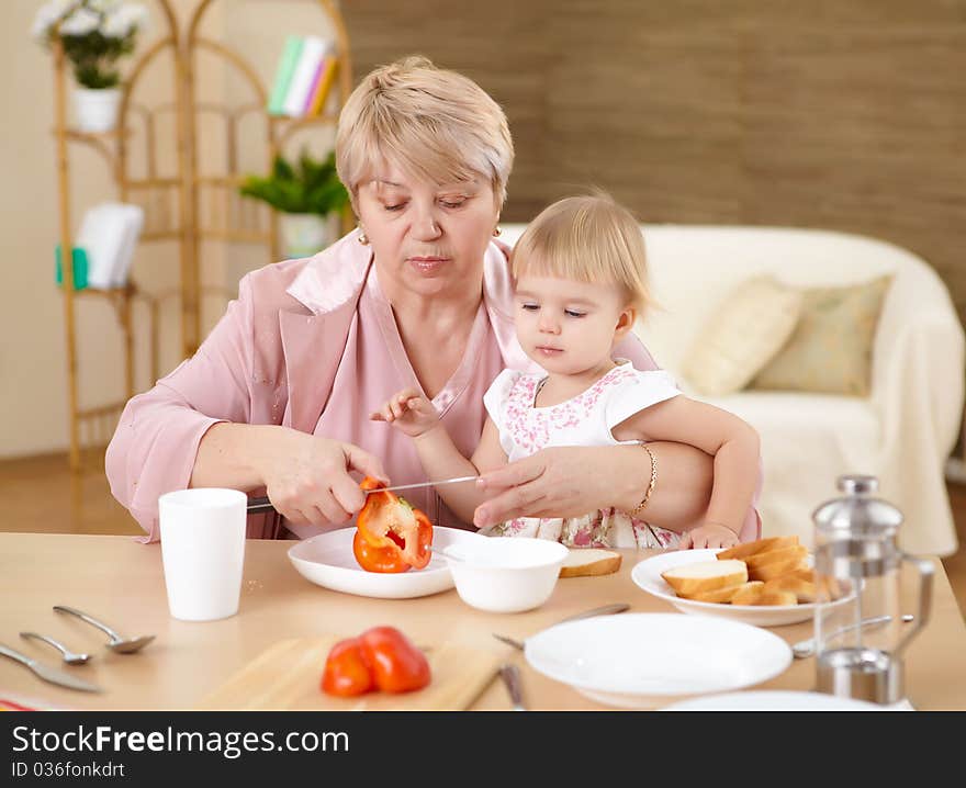 Grandmother feeding granddaughter at home