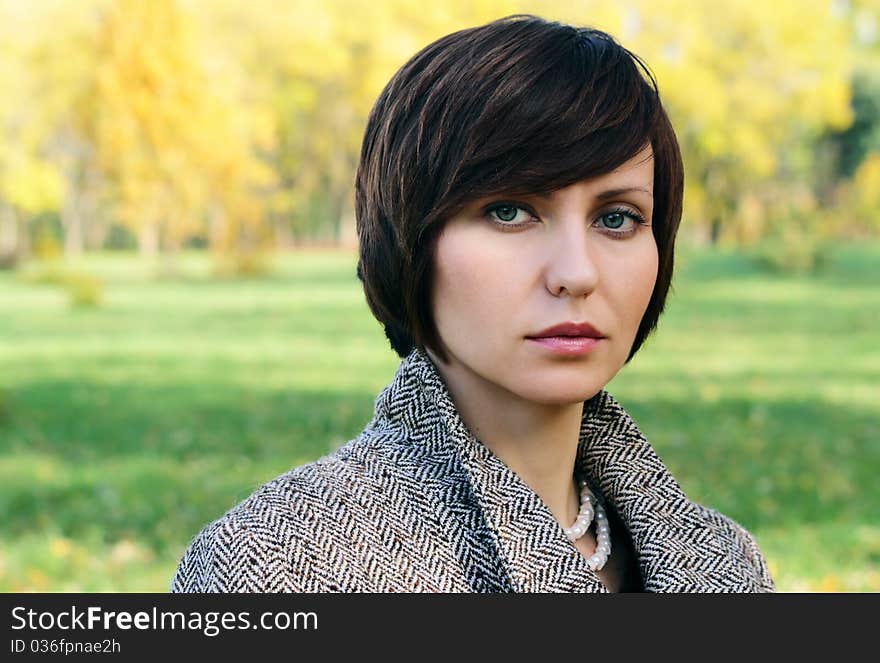 Woman in the autumn forest in the coat. Woman in the autumn forest in the coat