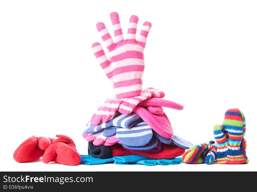 Pile of woollen garments and pink glove in greeting gesure at the top. Isolated over white. Pile of woollen garments and pink glove in greeting gesure at the top. Isolated over white