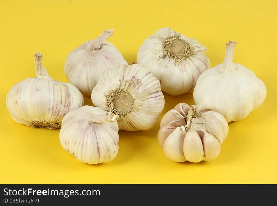 A pile of garlic on a yellow background