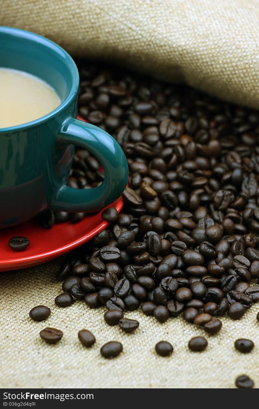 Coffee beans and a cup of coffee closeup