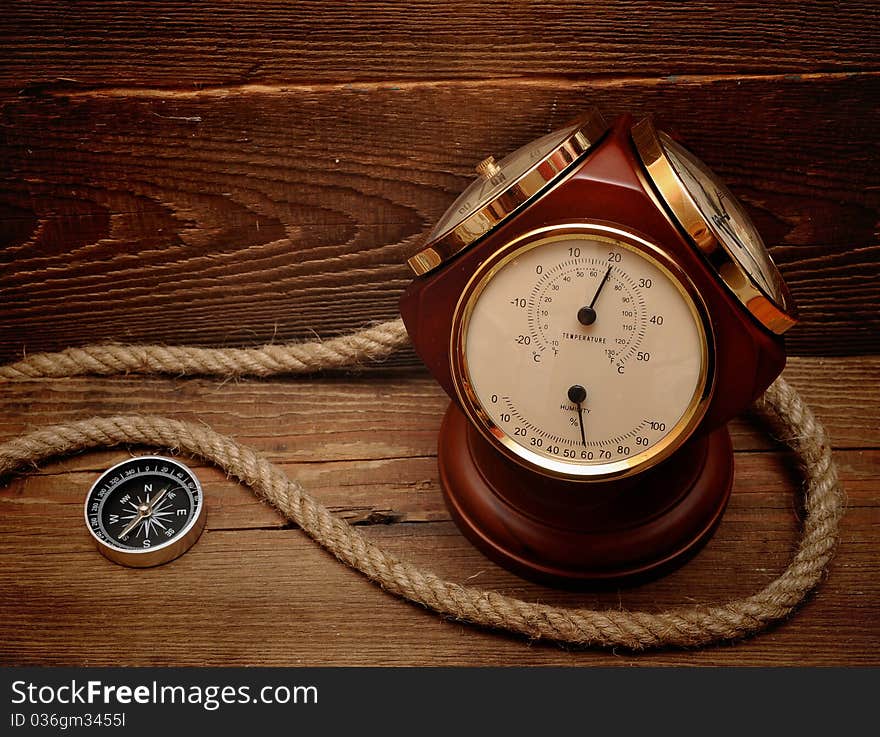 Old termometer, and compass on wood background. Old termometer, and compass on wood background