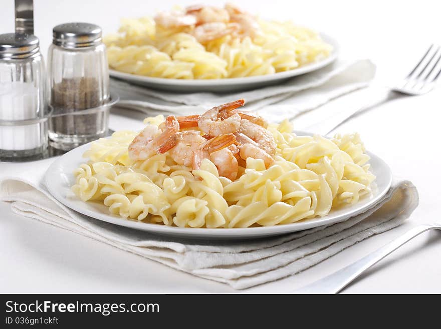 Two plates of pasta with prawns