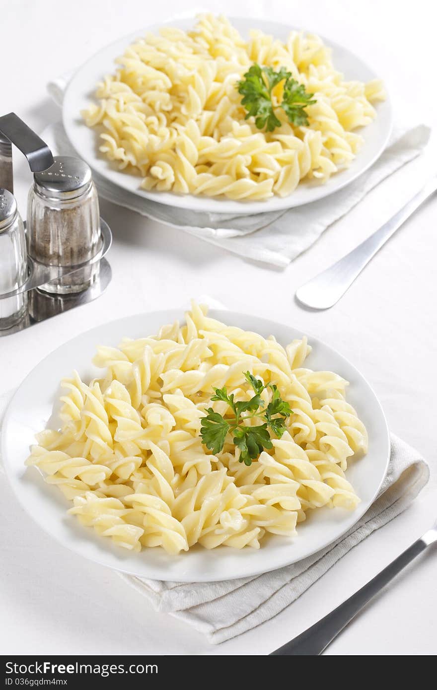 Two plates of pasta with parsley