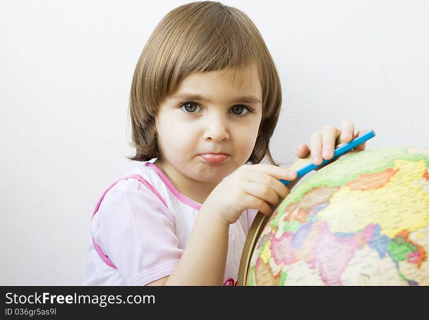 Little girl playing with a terrestrial globe, isolated on white. Little girl playing with a terrestrial globe, isolated on white