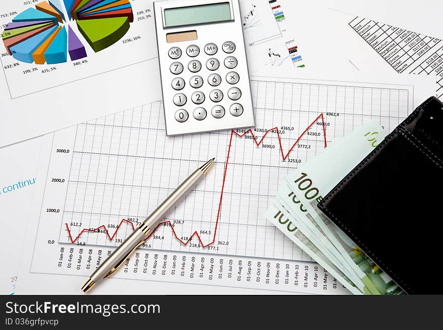 Financial charts and graphs on table with pen