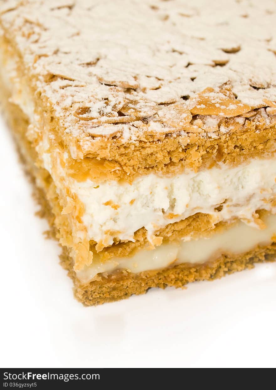 Cake almond with whipped cream and cream isolated on white close-up