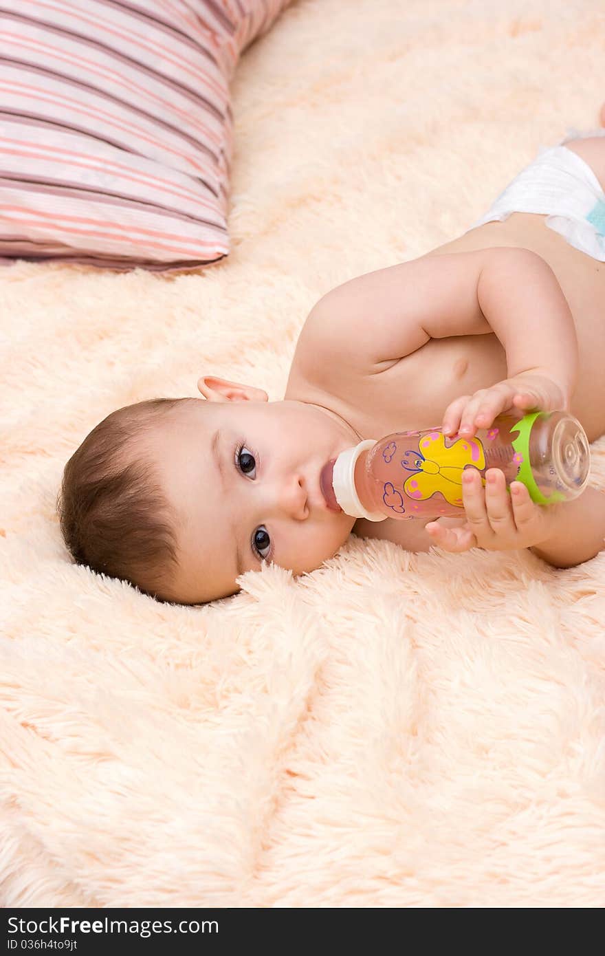 Little caucasian boy drinking juice from the bottle