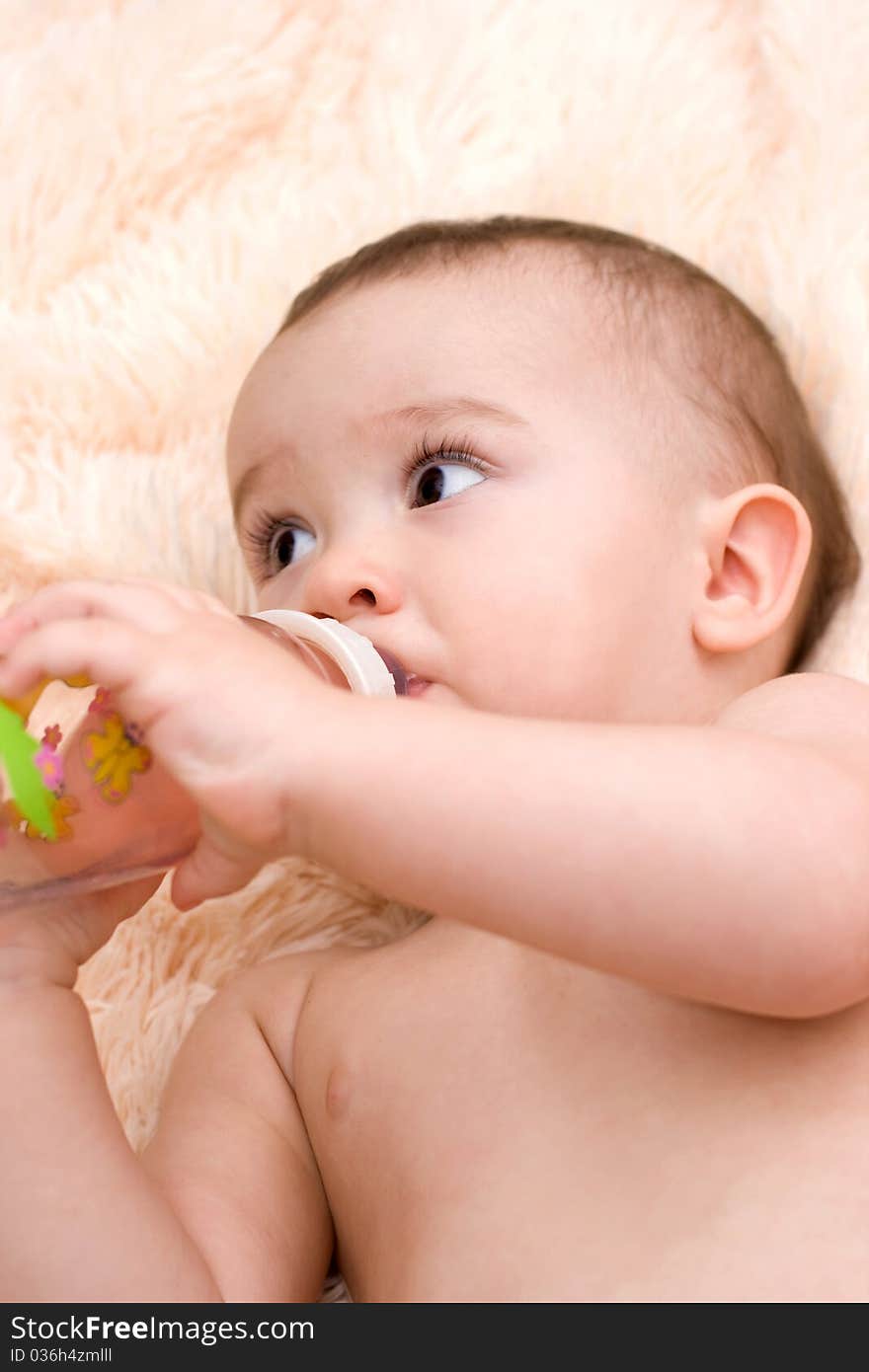 Little caucasian boy drinking water from the bottle