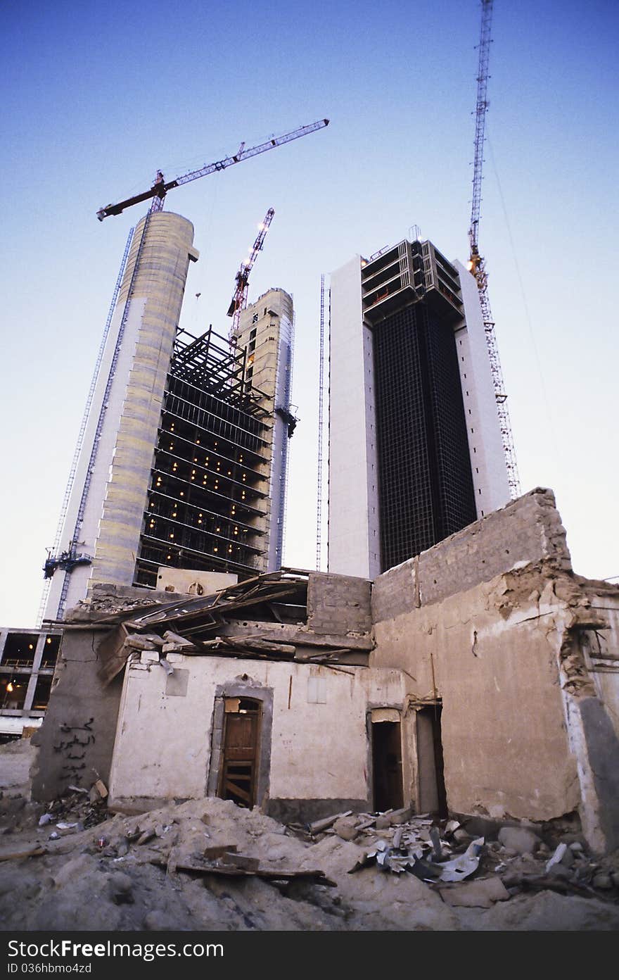 Two cranes putting up new buildings in front of demolished previous structure. Two cranes putting up new buildings in front of demolished previous structure