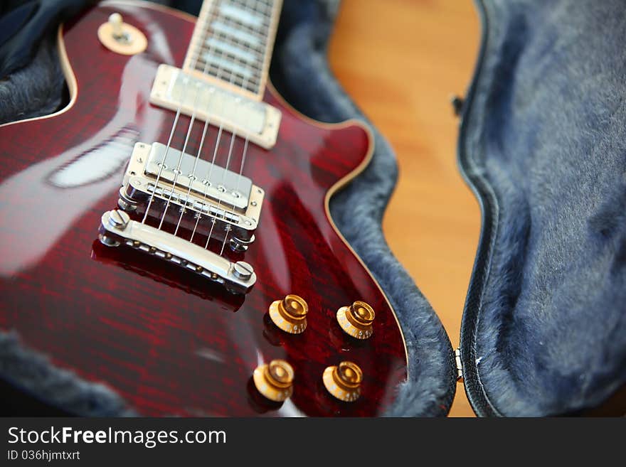 Electric guitar in the black case with strings and bridge