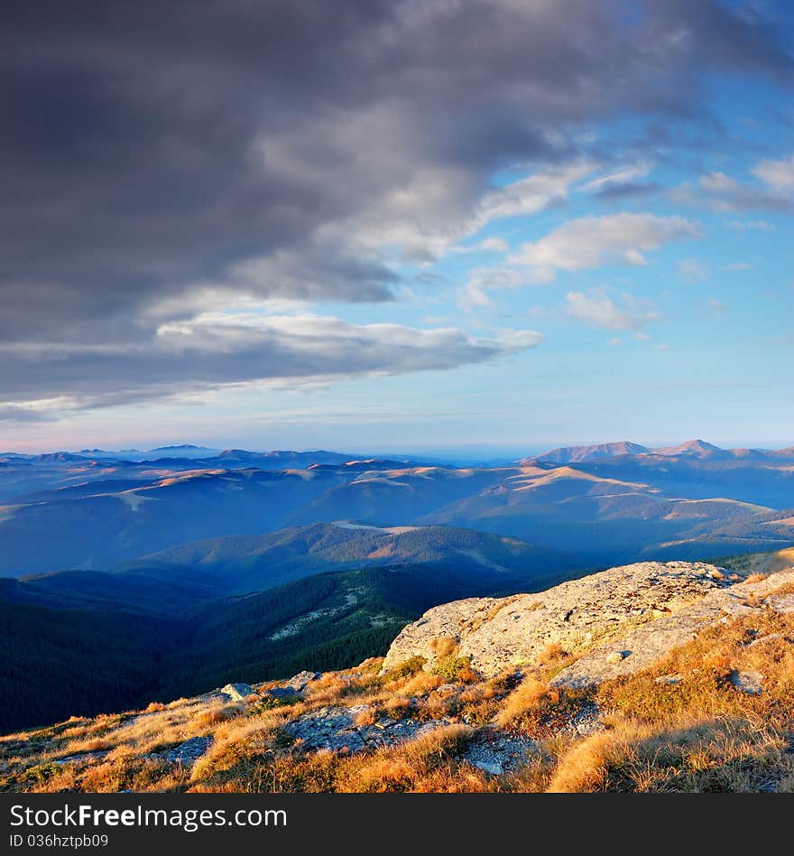 Summer landscape in mountains with the cloudy sky