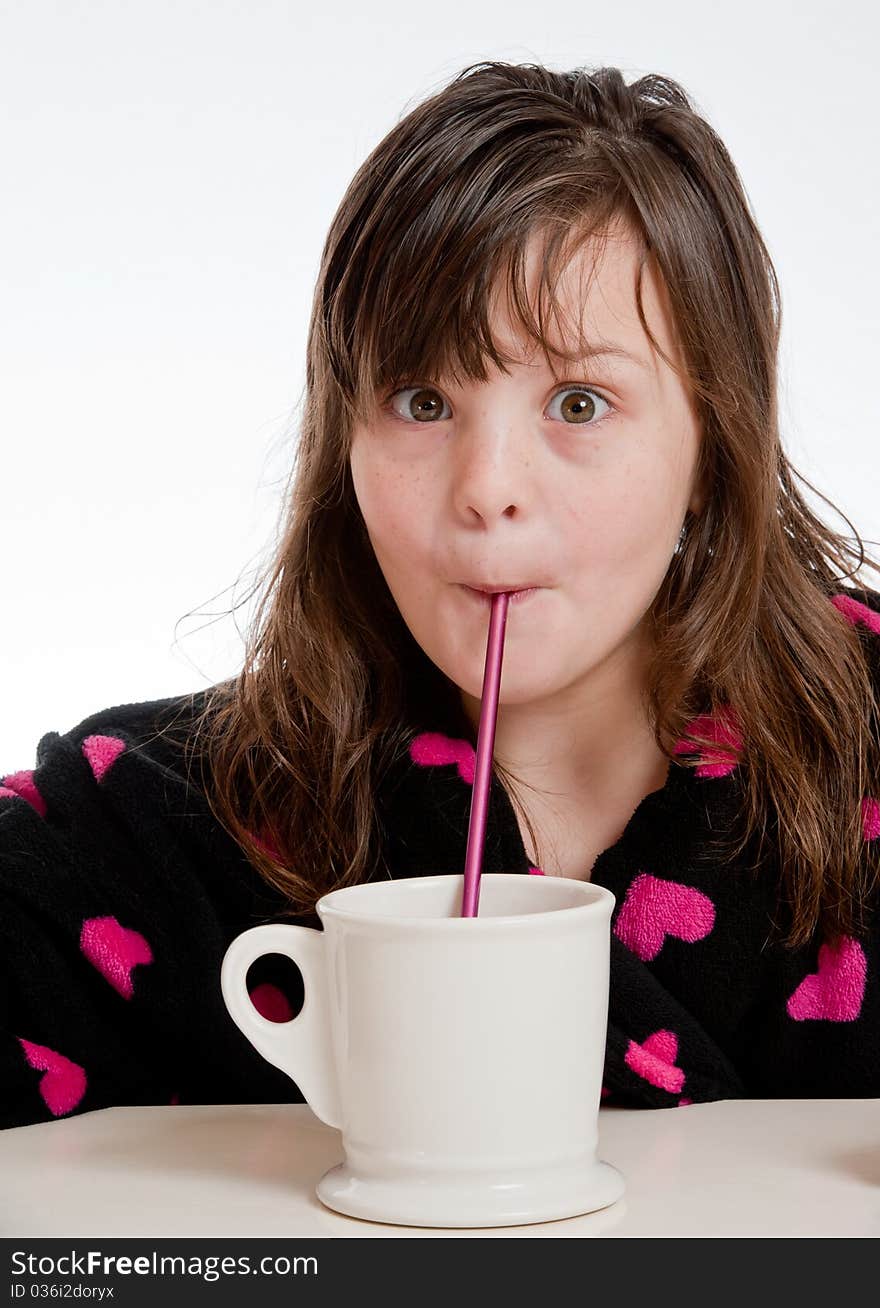 A girl sipping from a mug through a straw is surprised. A girl sipping from a mug through a straw is surprised.