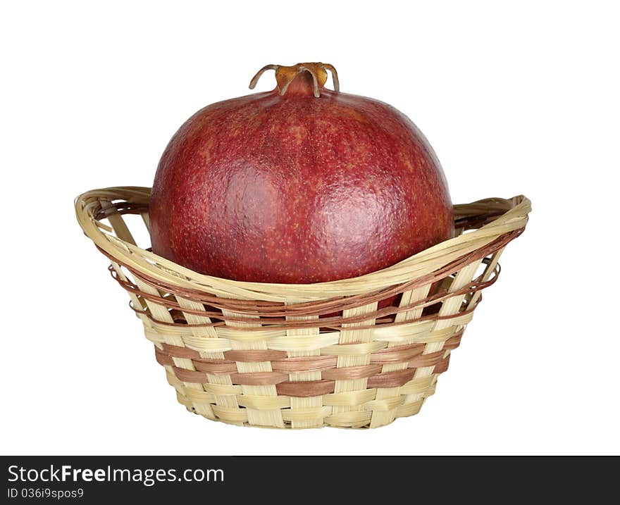 Ripe pomegranate in the basket isolated on a white background