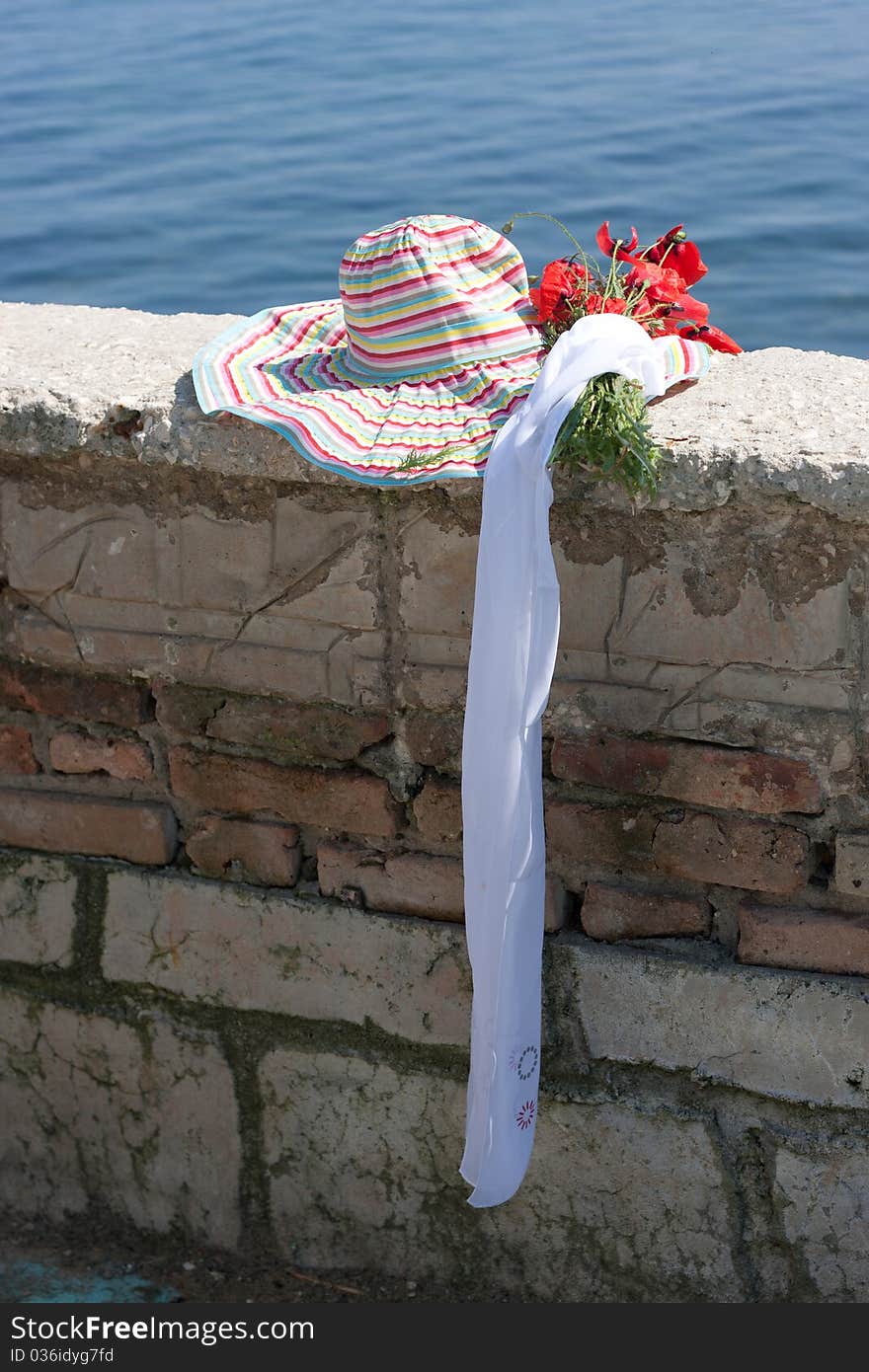 Woman's hat on a brick protection ashore sea