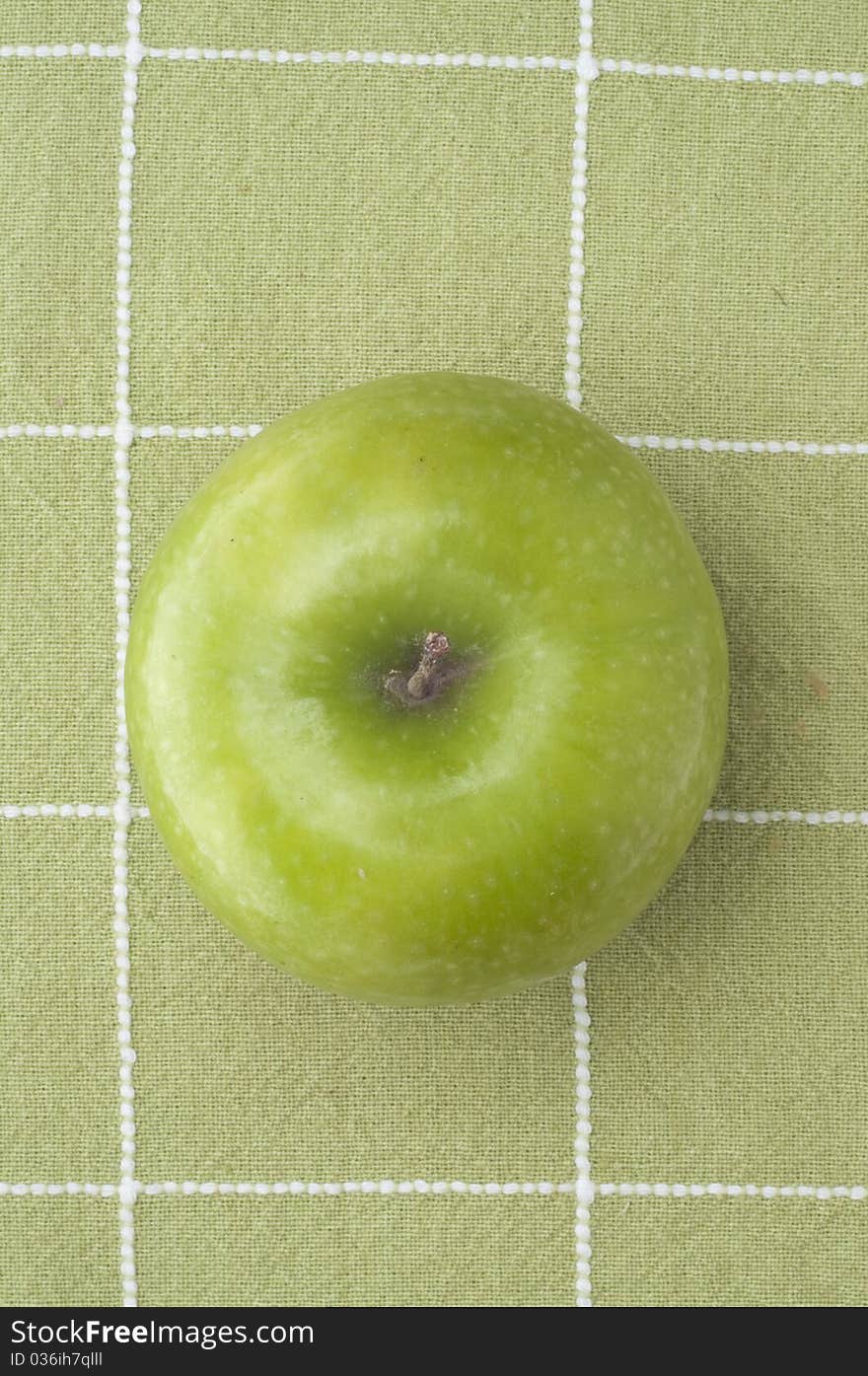 Fresh Green Tart Apple on a Green Background