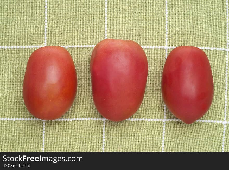 Fresh Trio of Roma Tomatoes on Green Kitchen Towel.