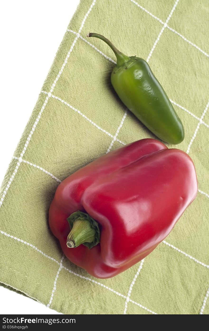 Red Bell Pepper and Jalapeno Pepper on Green Kitchen Towel.