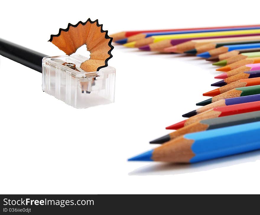 Lower view of colored pencils and sharpener on white background