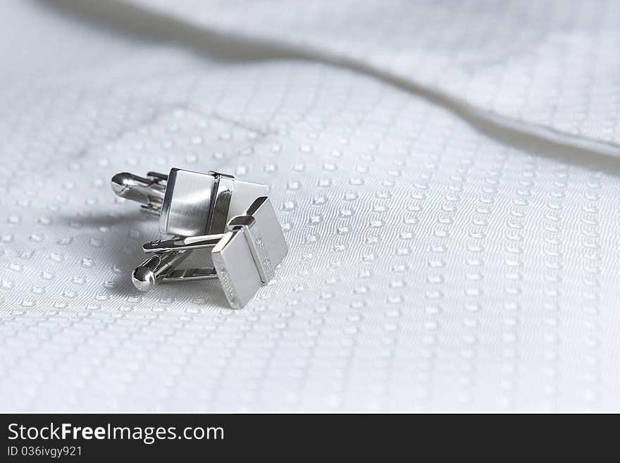 The grooms cufflinks rest on his waist coat.