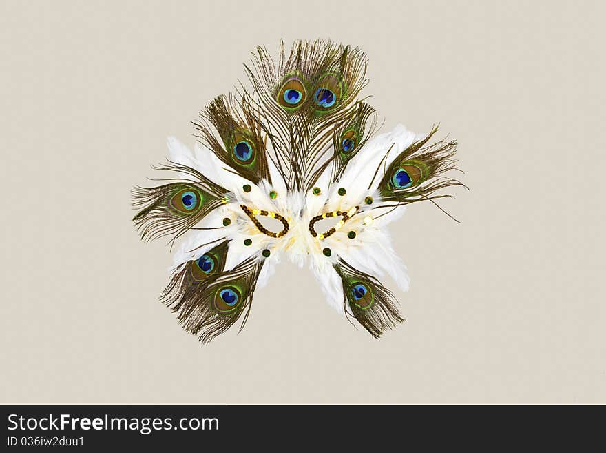 White and green carnaval mask made with feathers isolated on light cream