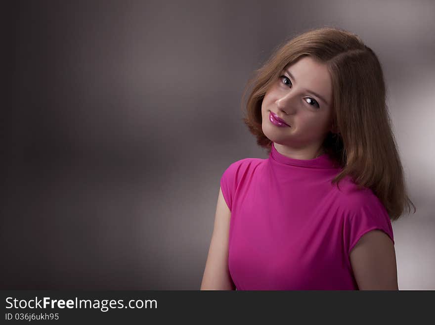 Portrait of the teenage girl in studio on a gray background. Portrait of the teenage girl in studio on a gray background