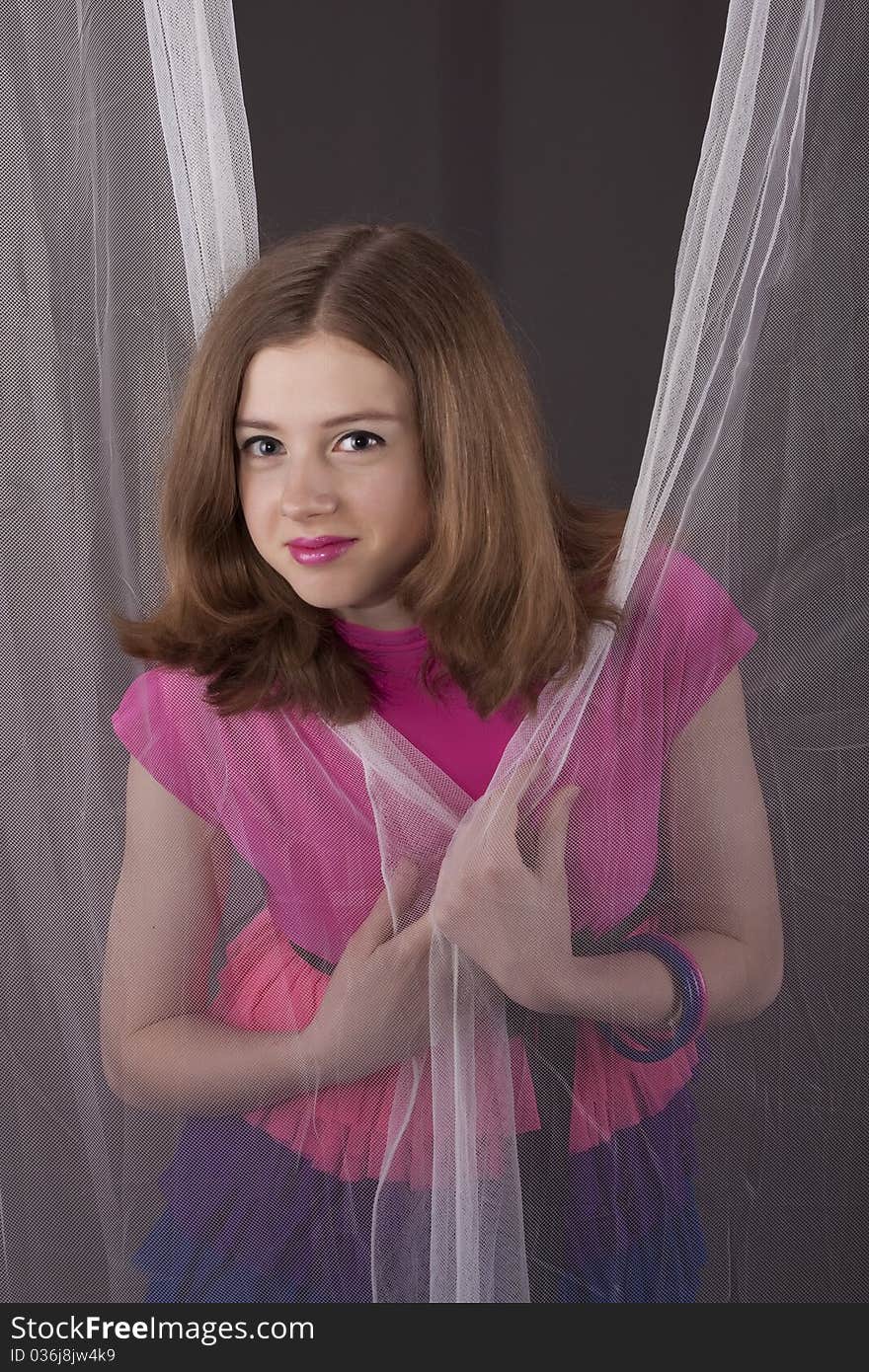 Portrait teenager girl between curtains