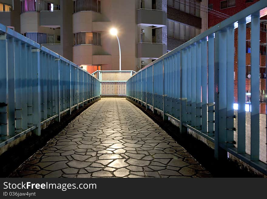 On the pedestrian bridge,the street lamp light the way. On the pedestrian bridge,the street lamp light the way