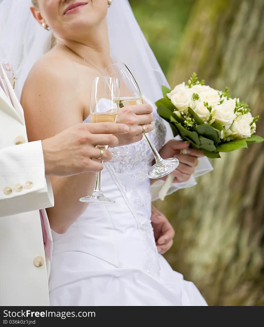 Bride and fiance are holding wedding glass