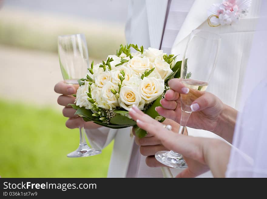 Bride checks her nails while fiance holds wedding bouquet. Bride checks her nails while fiance holds wedding bouquet