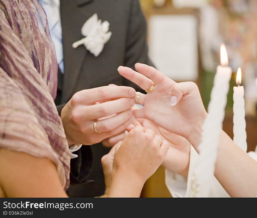 Fiance is putting on wedding ring on bride's finger. Fiance is putting on wedding ring on bride's finger