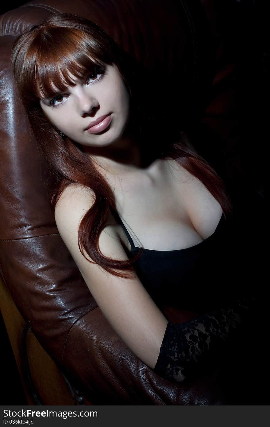 Portrait Of Young Woman Sitting On Leather Chair