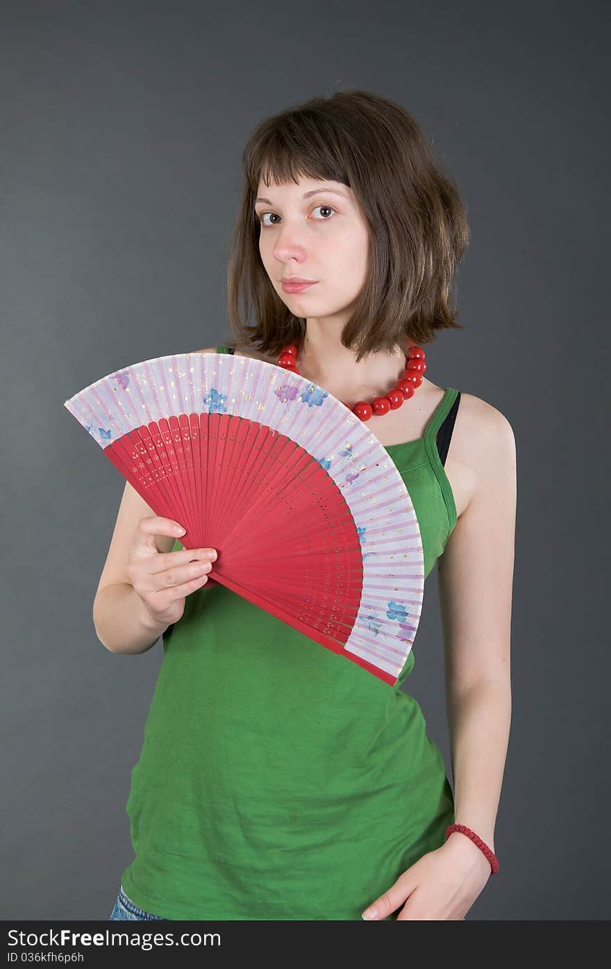 Girl with a fan on a black background