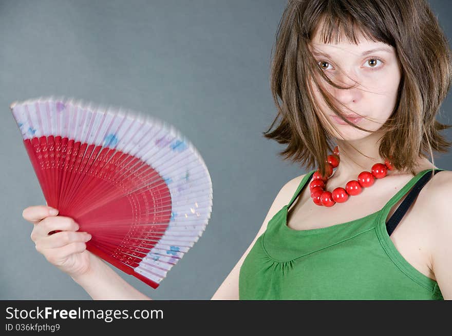 Girl with a fan on a black background