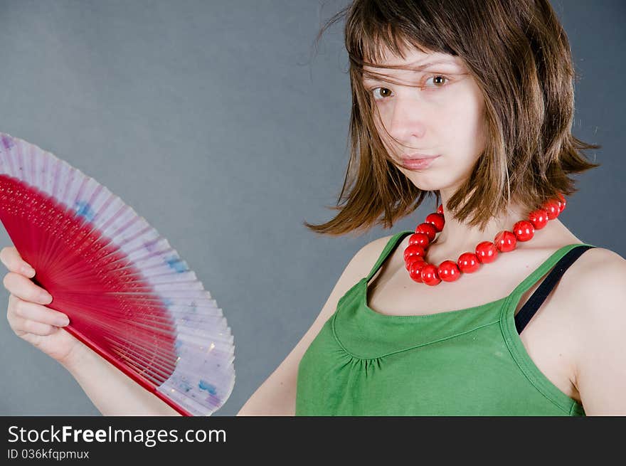 Girl with a fan on a black background