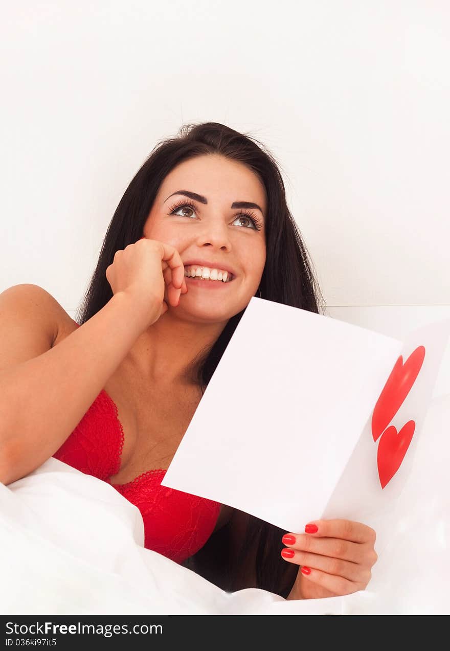 Girl lying in bed with gifts, cards, hearts