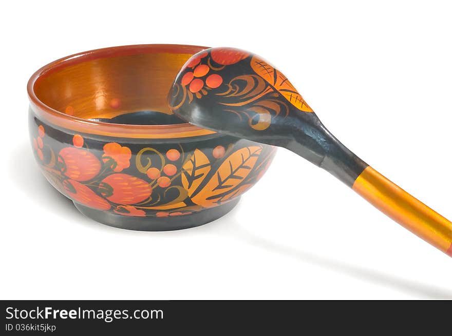 Painted wooden plates and spoons against white background