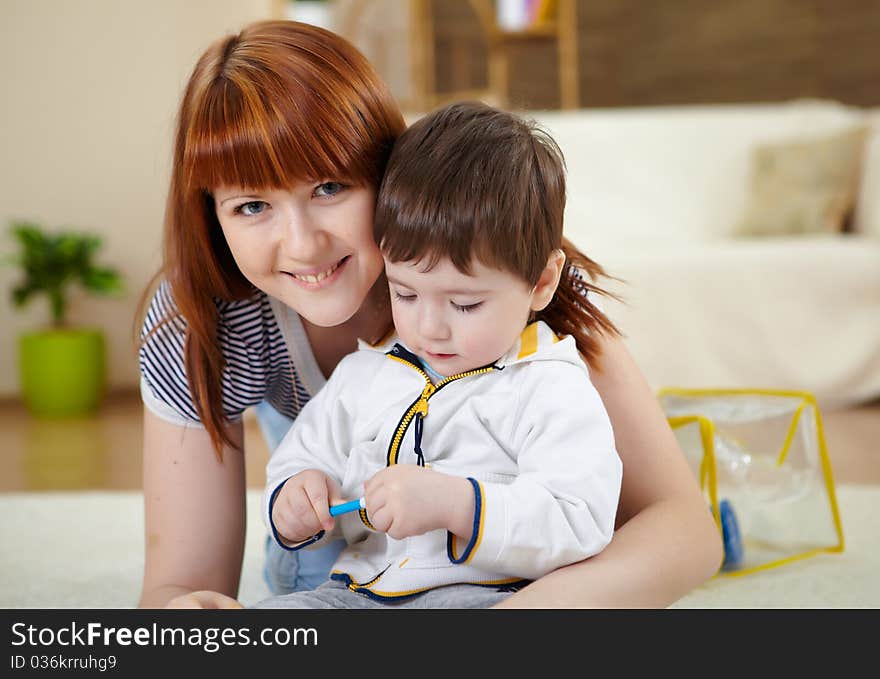 Mother playing with her little son at home on the floor. Mother playing with her little son at home on the floor