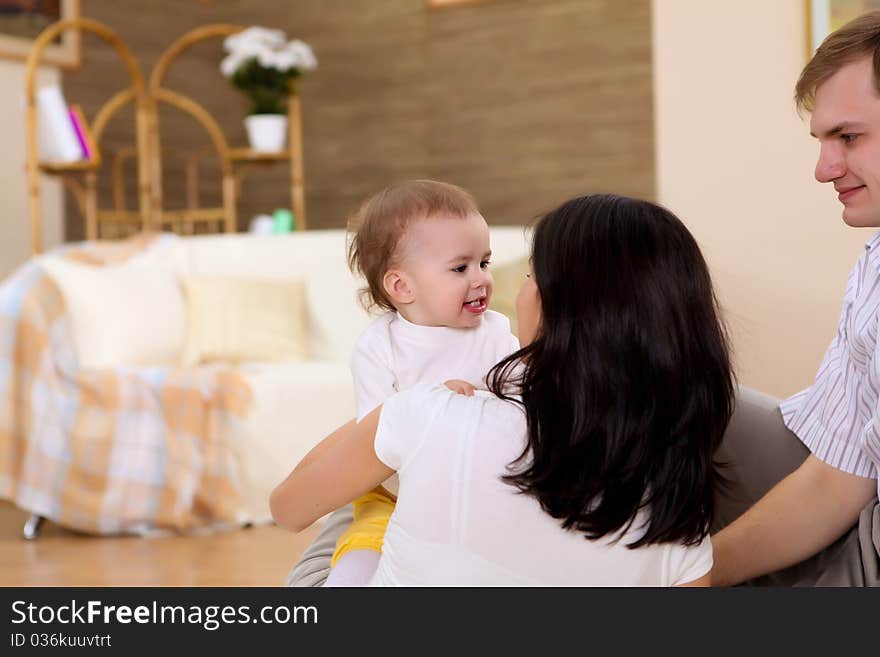 Young Family At Home Playing With A Baby