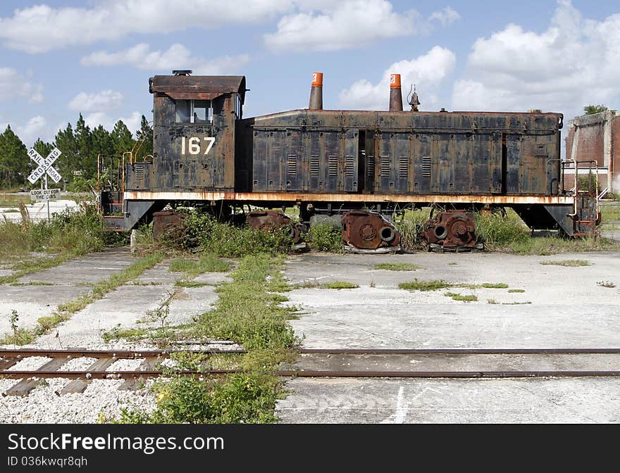 Abandoned 1940's diesel electric locomotive by a rail road crossing. Abandoned 1940's diesel electric locomotive by a rail road crossing.