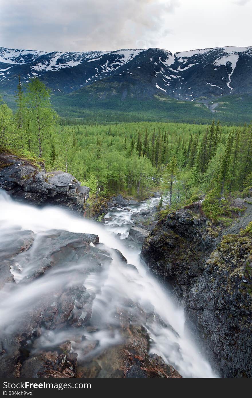 View from above waterfall on forest and mountains