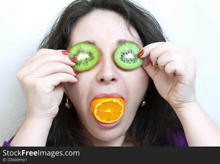 Woman holds two slices of kiwi before her eyes