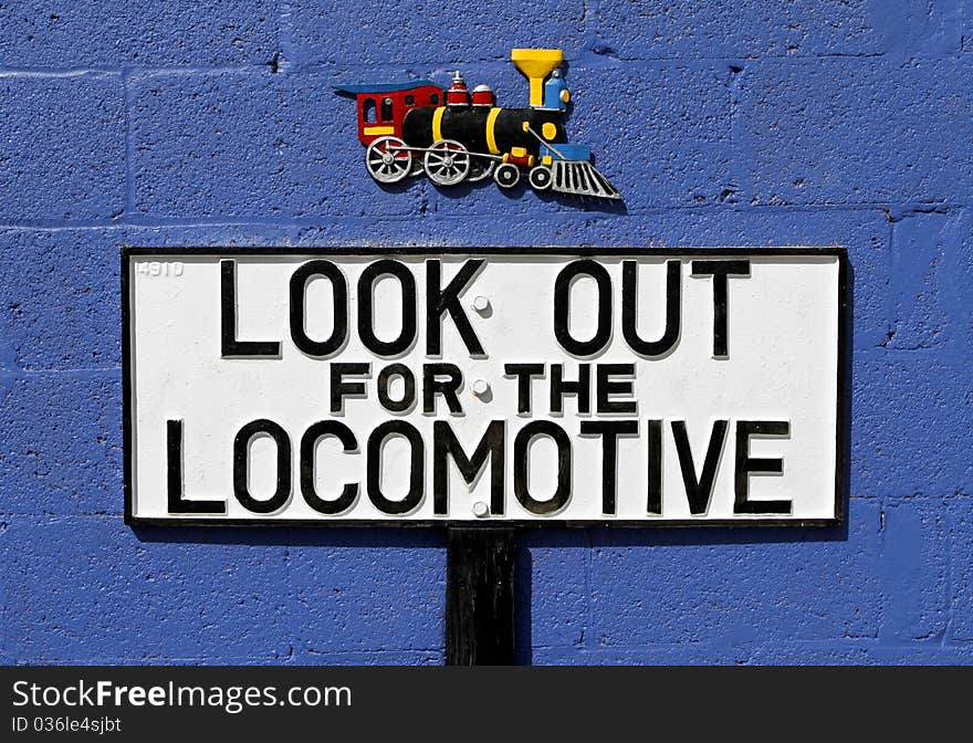 Old cast metal sign warning of the approach of a locomotive. Old cast metal sign warning of the approach of a locomotive.