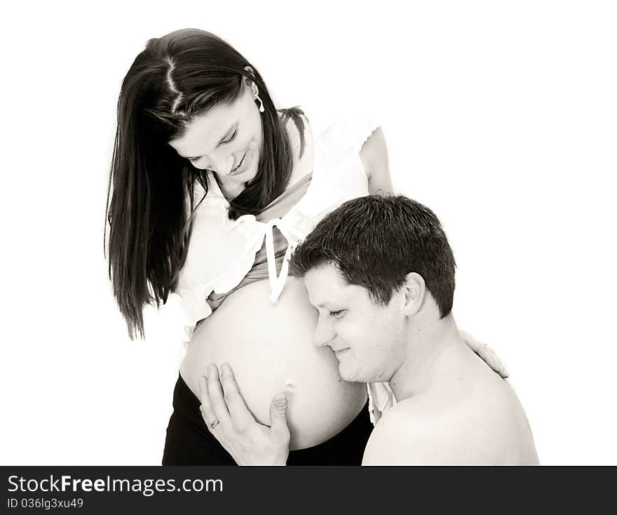 Toned image of father listening to mother's pregnant belly. Toned image of father listening to mother's pregnant belly.