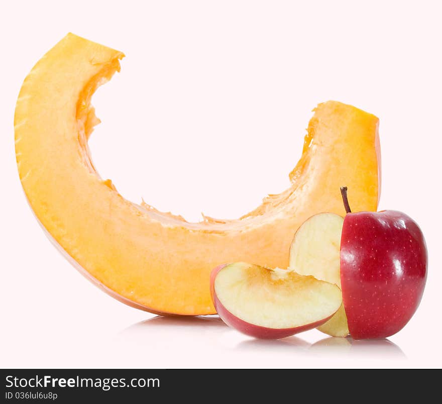 Pumpkin slice with sliced red apple on the white