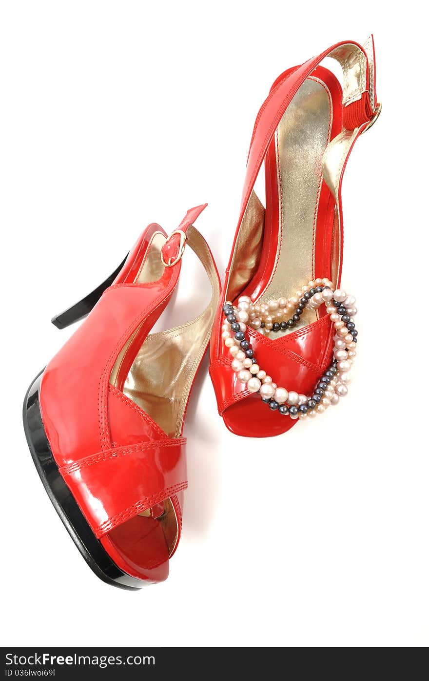 Woman red shoe with pearl necklace on a white background