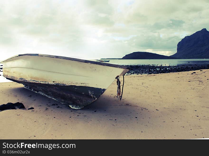 An old boat found on the beach of a unique sea. A moutain comes out directly from the sea itself. An old boat found on the beach of a unique sea. A moutain comes out directly from the sea itself.