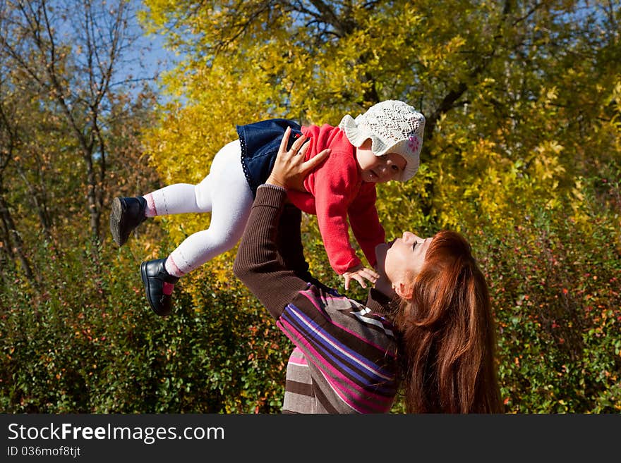 A ginger-haired woman holds her baby in her arms. A ginger-haired woman holds her baby in her arms