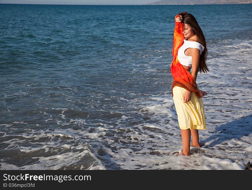 A young woman with the pareo is on a coast