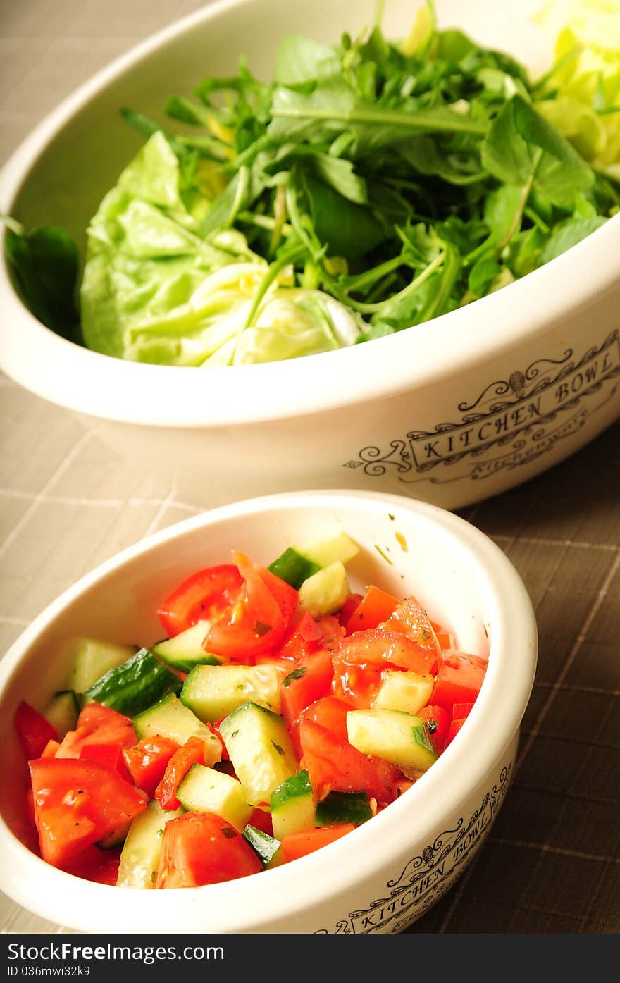 Two kitchen bowls filled with fresh salad